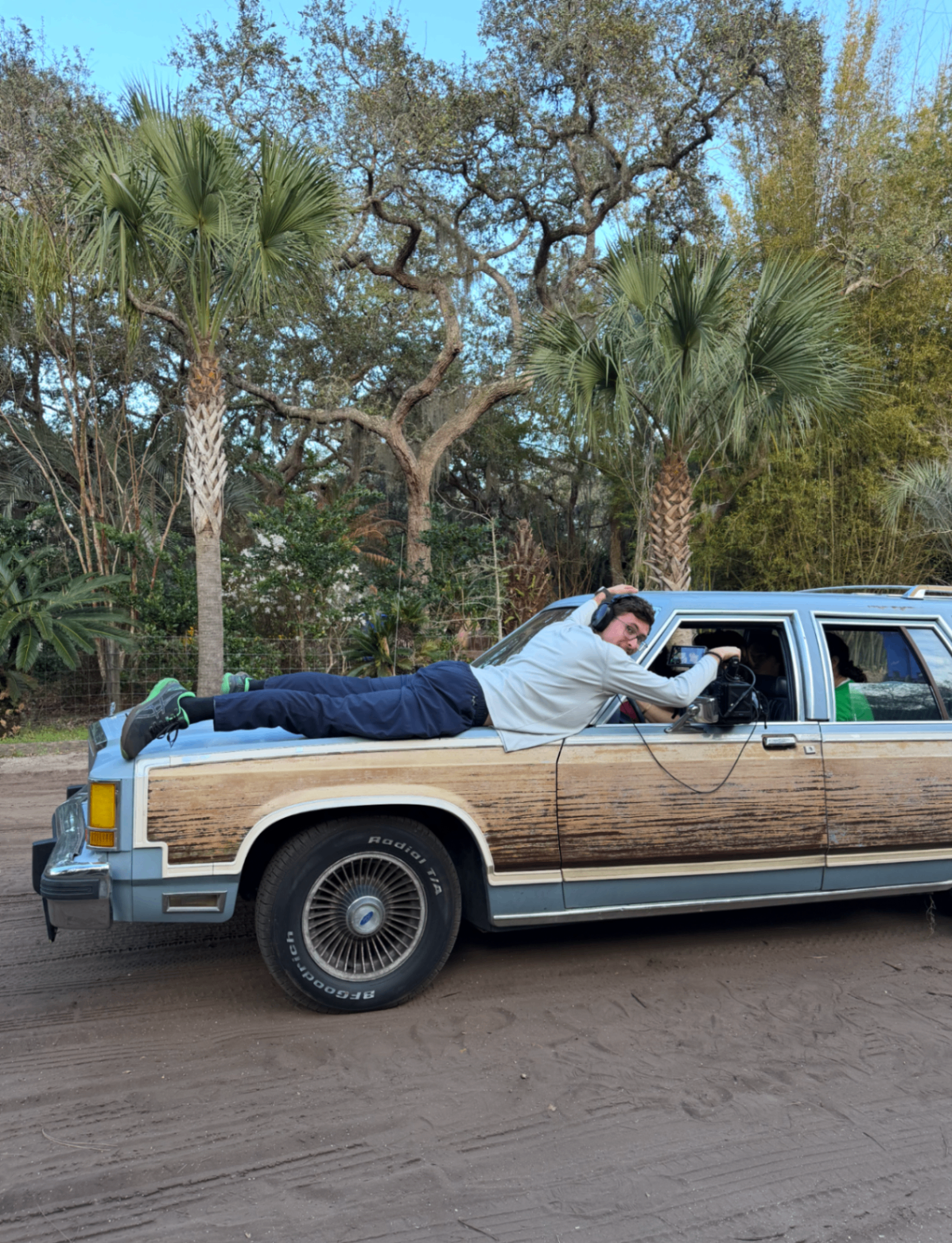 Filming a rolling shot off the hood of a vintage wagon