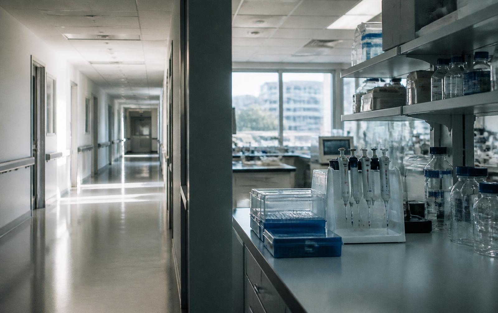 A modern hospital corridor beside a medical research laboratory bench in daylight.